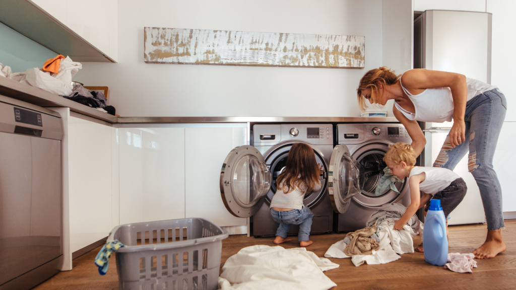 Woman and two toddlers doing laundry together