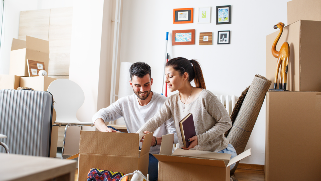 Couple packing things into cardboard boxes at home.