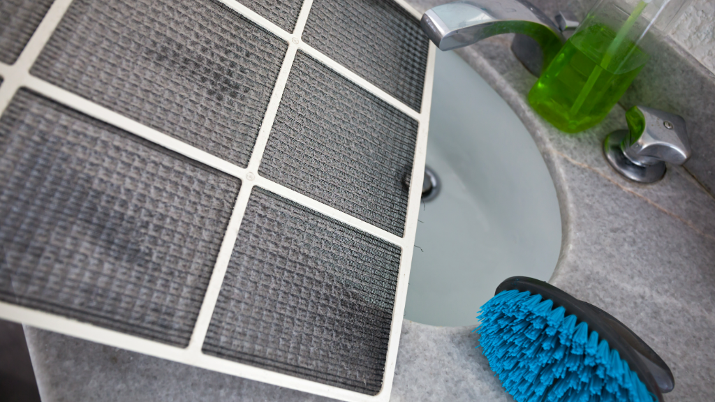 HVAC filter and blue brush in the sink.