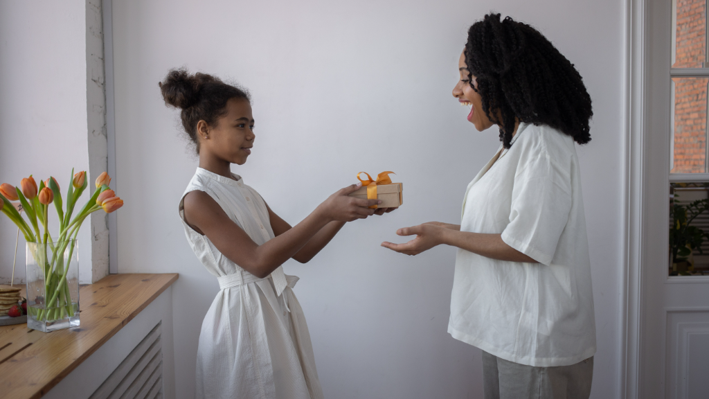 Daughter handing a small gift to her mother
